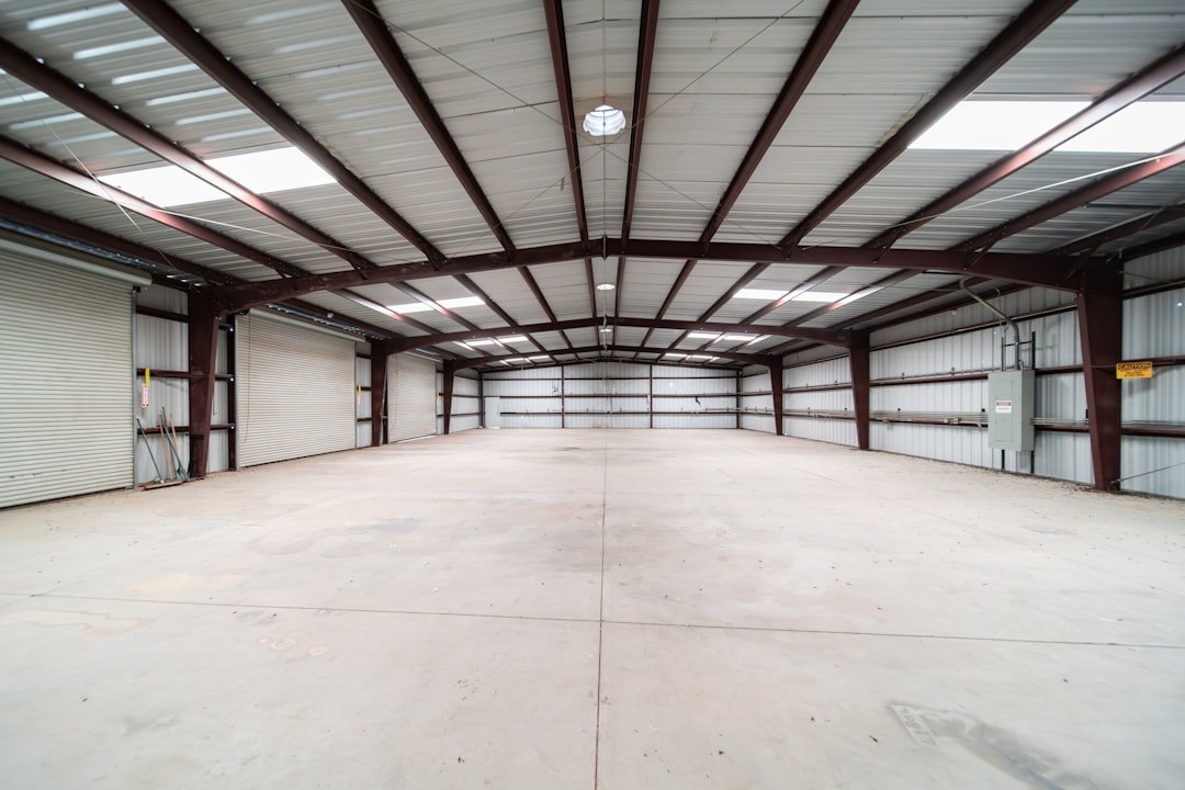 Interior of a completed steel industrial shed with portal frames, purlins and roll-up doors